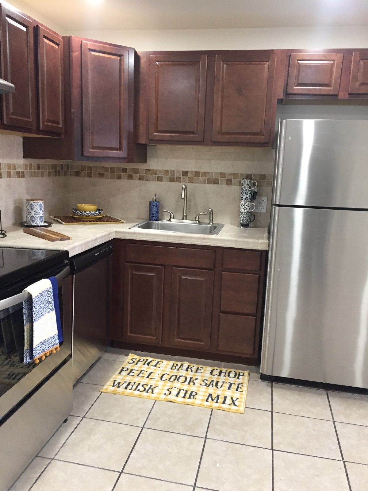a kitchen with stainless steel appliances and a rug on the floor